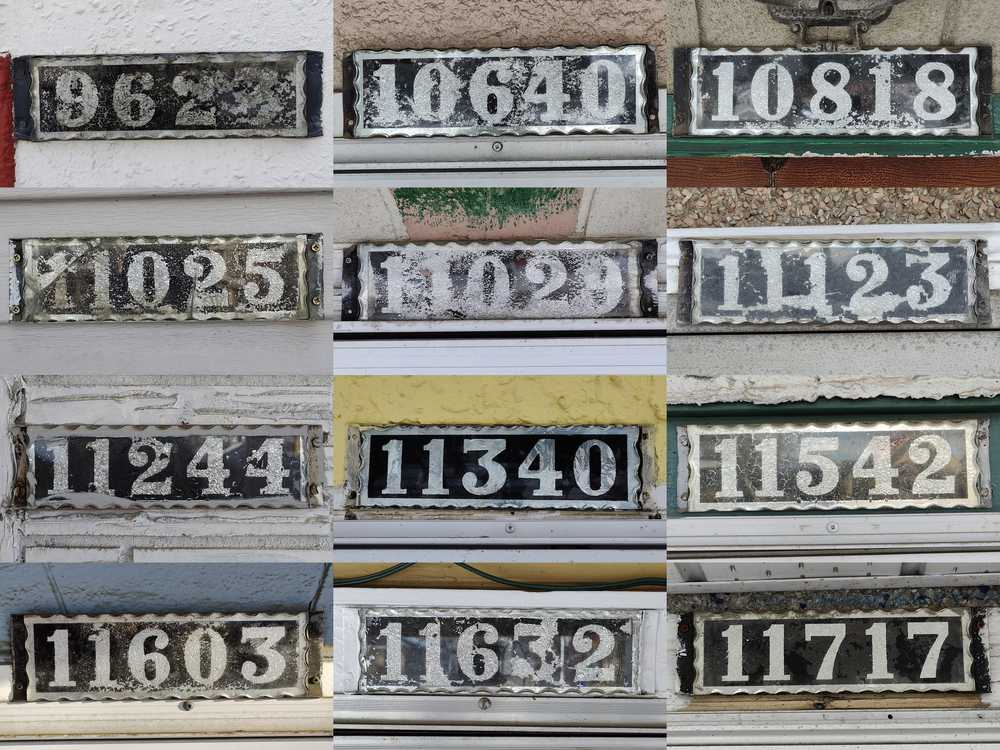 Twelve old house number plates sharing similar characteristics.