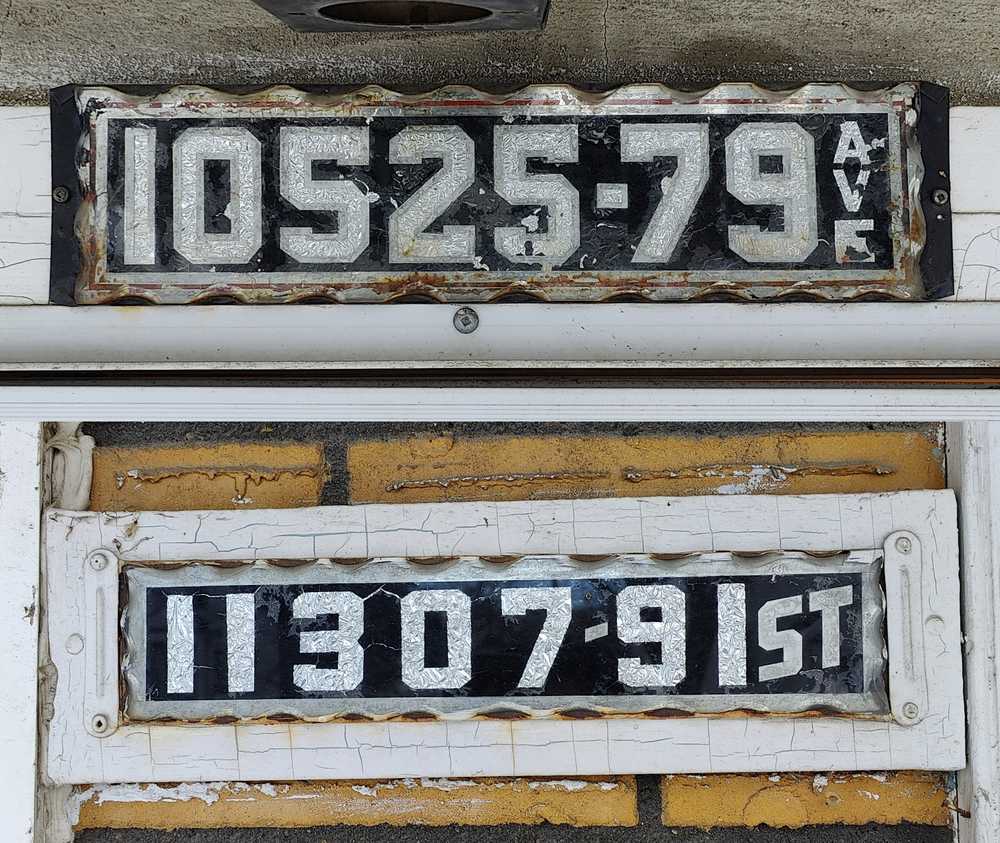 Two unusually long number plates with the street name included.