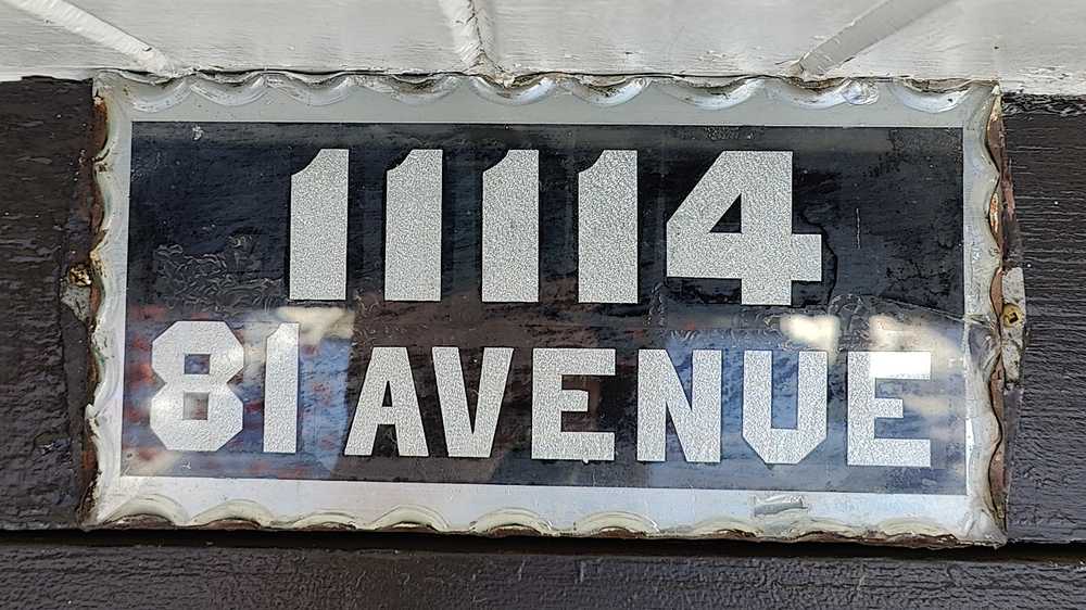 An unusually tall number plate with two lines of text.