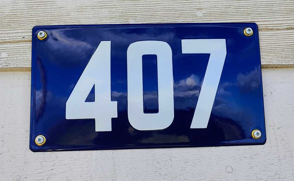 A physical reproduction of an old Regina house number plate.