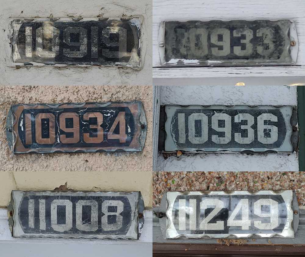 Six old house number plates sharing similar characteristics.