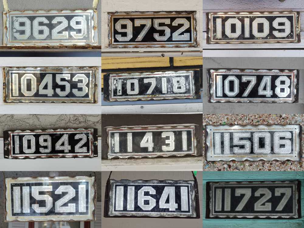 Twelve old house number plates sharing similar characteristics.